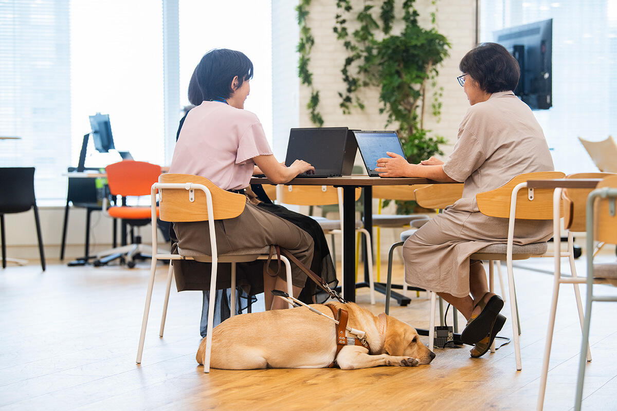 盲導犬を連れて出社する従業員の姿